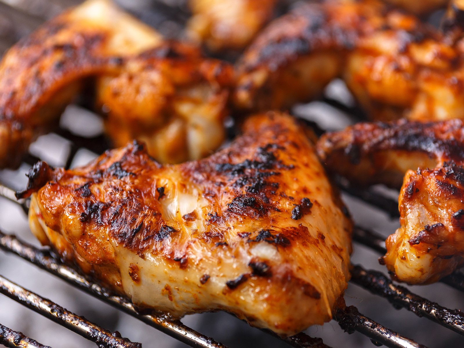 Spatchcocked chicken marinated in a dry rub overnight, grilled over two zones, and glazed in the last 10 minutes with a homemade bourbon BBQ sauce. The smoke, the char, the glaze.
