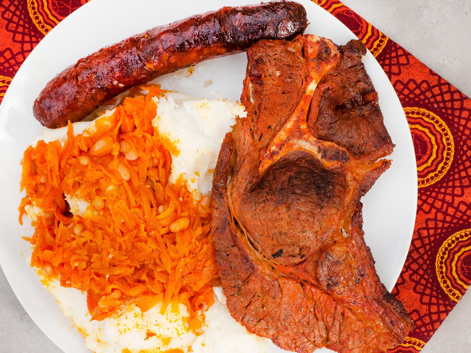 A spicy, tangy relish of onions, peppers, carrots, and baked beans that goes with everything. A South African braai essential. Bold, colorful, and endlessly versatile as a side, topping, or sauce.