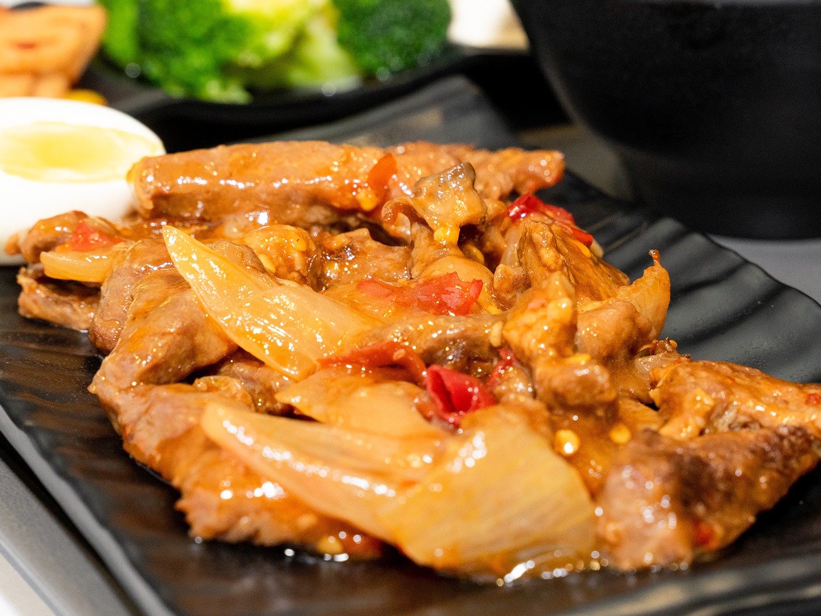West African street food at its finest. Thin beef strips coated in suya spice — groundnut powder, ginger, paprika, garlic, and chili — grilled over charcoal until smoky and slightly charred. Served with sliced onions and tomatoes.