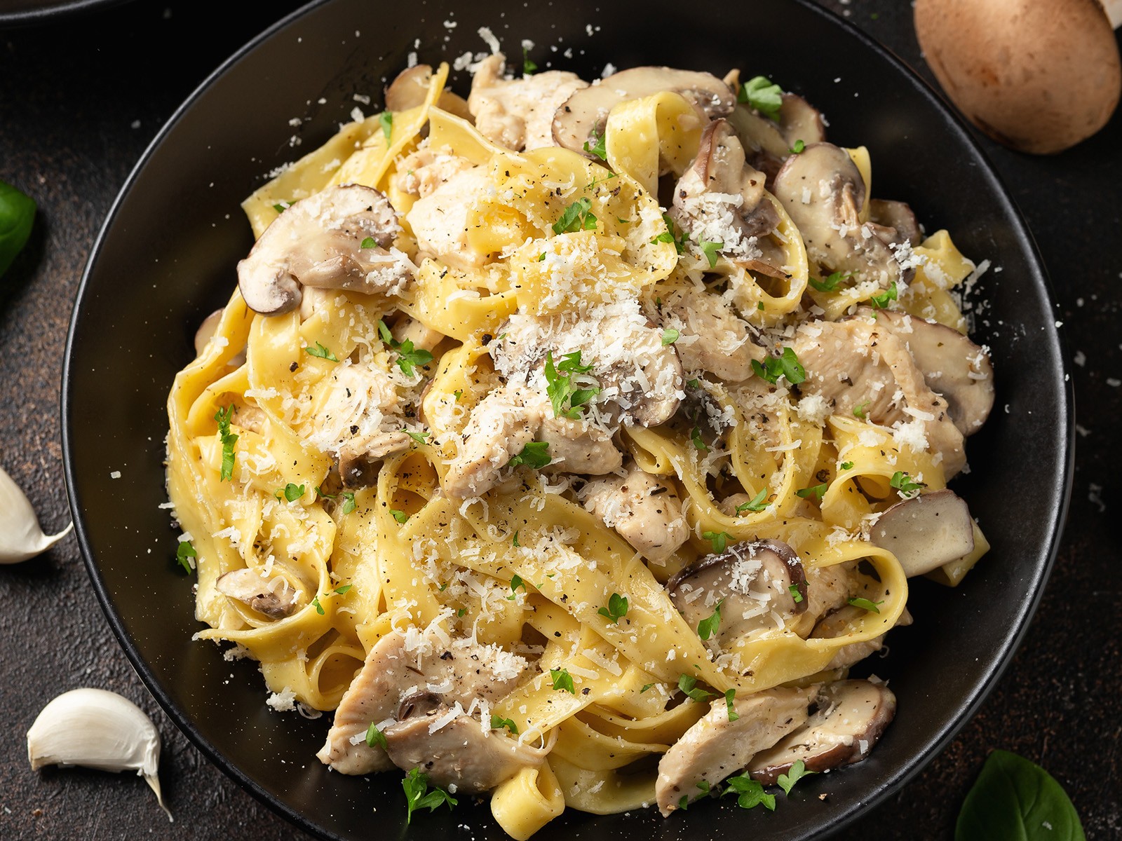 Grilled chicken over fettuccine in a real Alfredo sauce — butter and parmesan with pasta water, no cream needed. The emulsification is the skill. When it works it coats every strand perfectly.