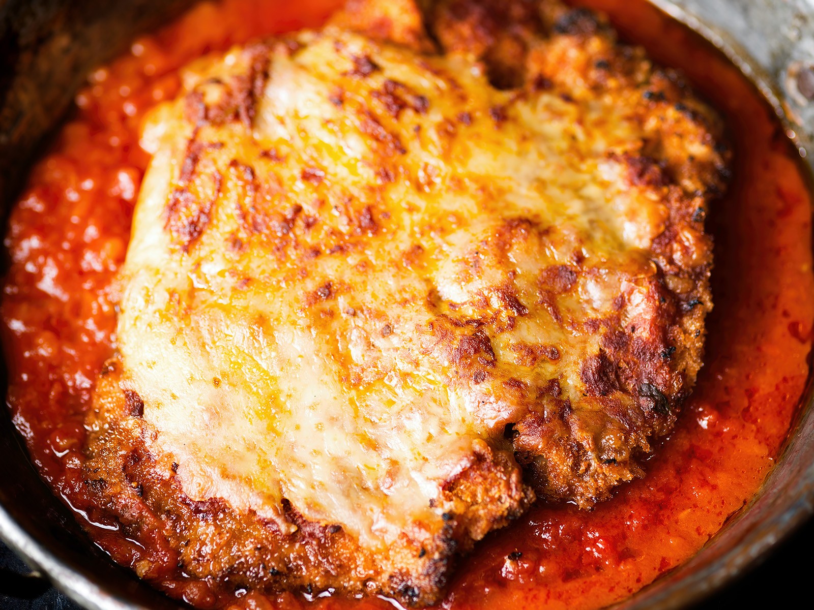 Pounded chicken breast, breaded in panko and parmesan, fried until shatteringly crispy, then topped with a quick San Marzano tomato sauce and fresh mozzarella broiled until bubbling.