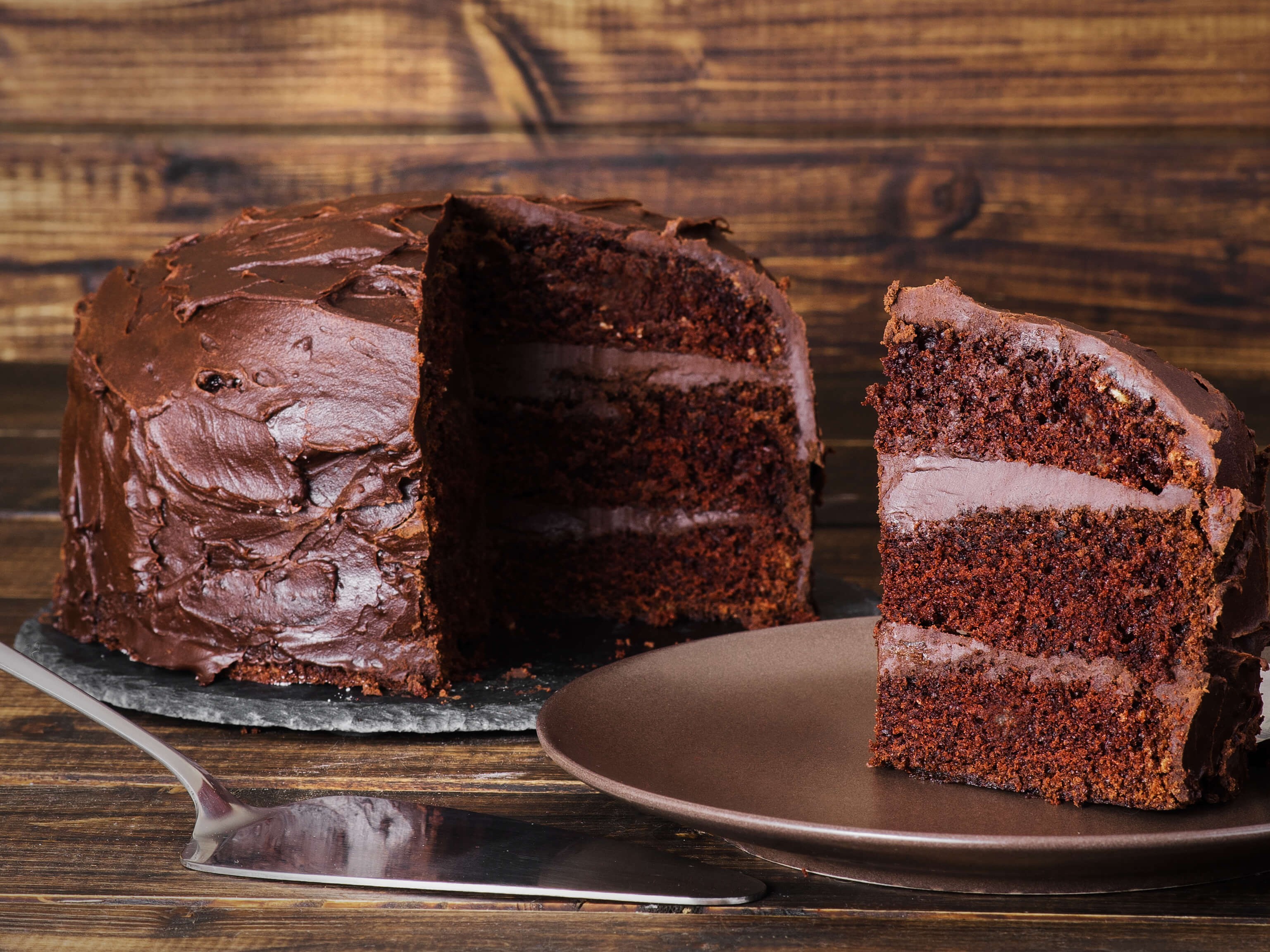 Three layers of devil's food cake — buttermilk, hot coffee, and Dutch cocoa — with a whipped dark chocolate ganache frosting. The coffee amplifies the chocolate. The frosting sets up silky and smooth.