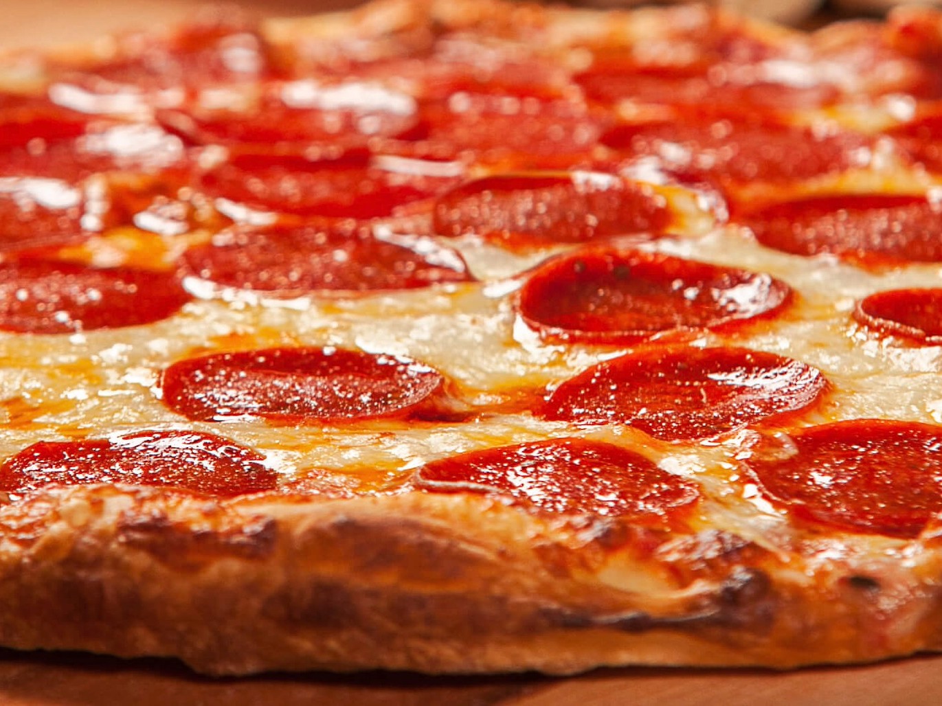 New York-style pizza dough fermented 72 hours in the refrigerator, stretched thin, topped with crushed San Marzano tomatoes, whole-milk mozzarella, and pepperoni that pool that flavorful grease. Done right in a home oven.