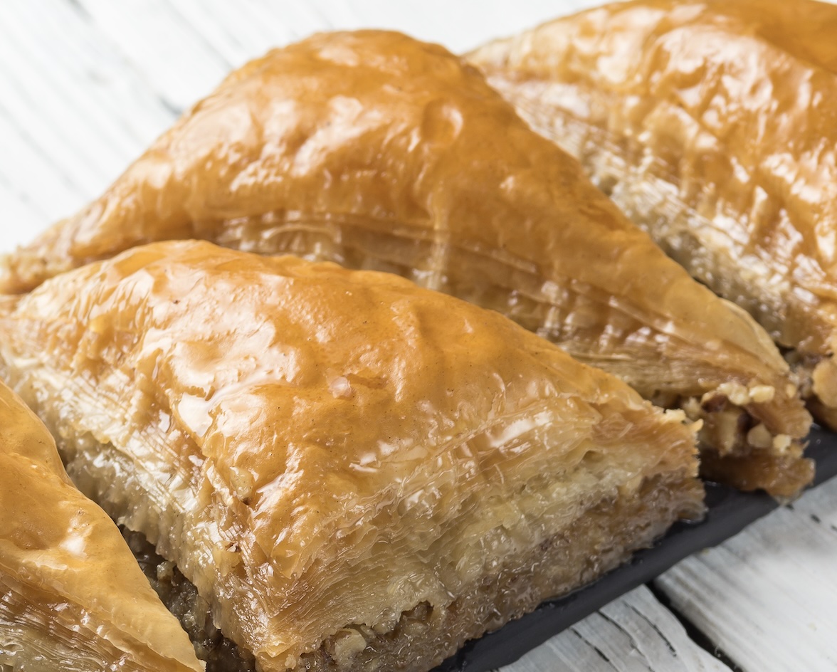 Layers of flaky phyllo dough filled with crushed nuts and soaked in a sweet honey syrup. A rich, iconic dessert treat.
