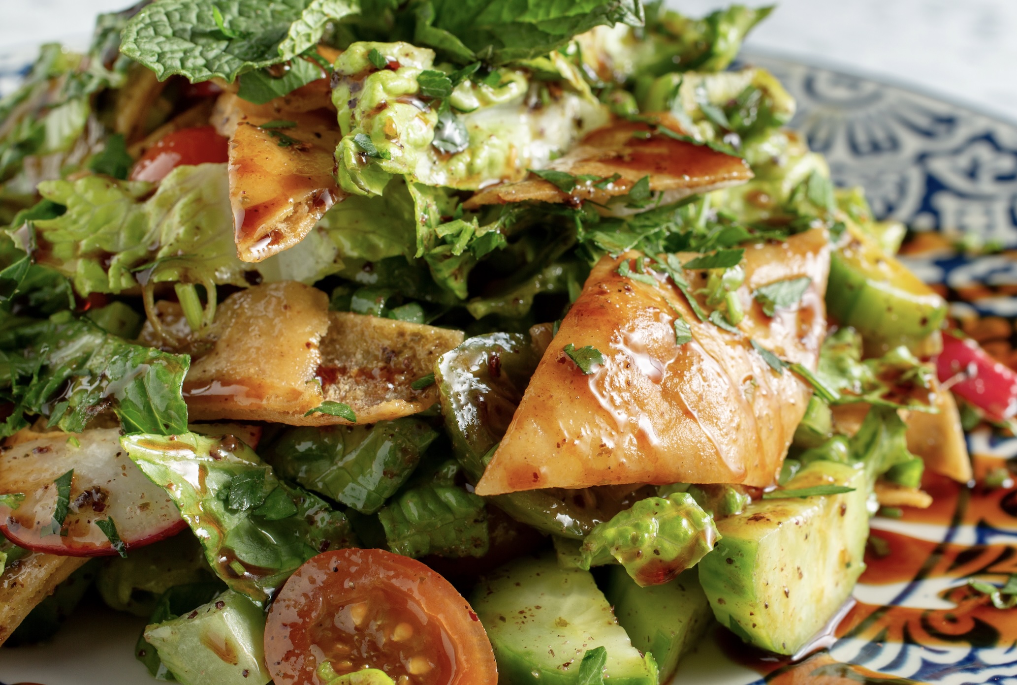A rustic bread salad featuring crispy fried pita, garden vegetables, and a tangy sumac vinaigrette. Crunch in every bite.