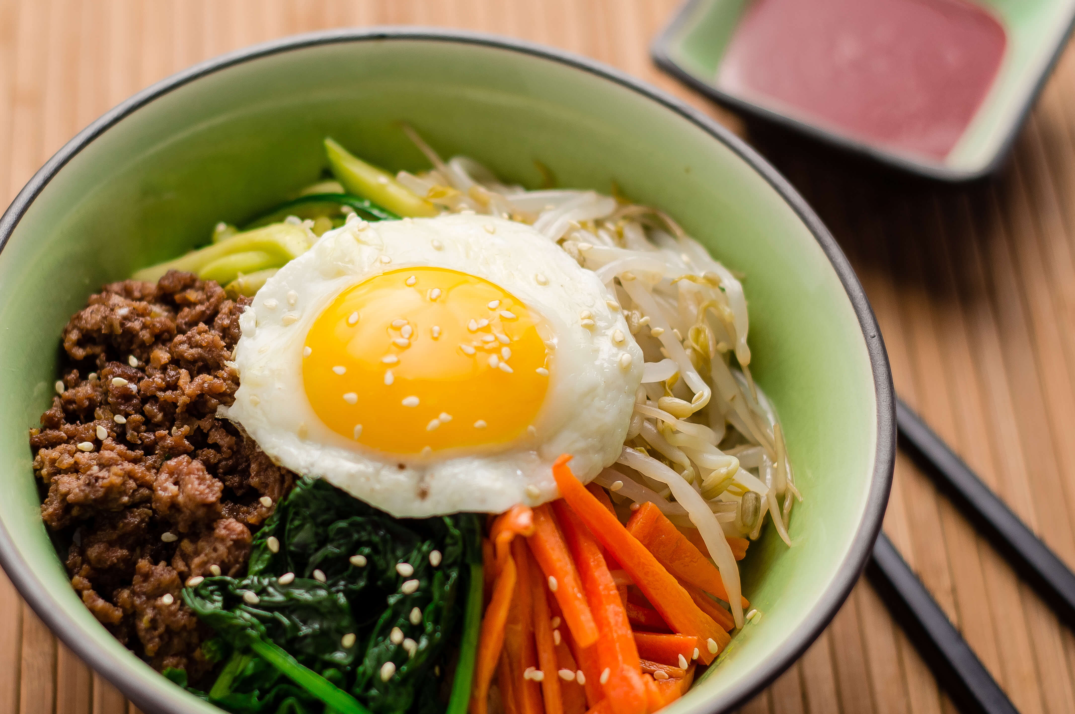 Rice topped with sautéed veggies, beef, and a fried egg, mixed with spicy gochujang for bold Korean flavor.
