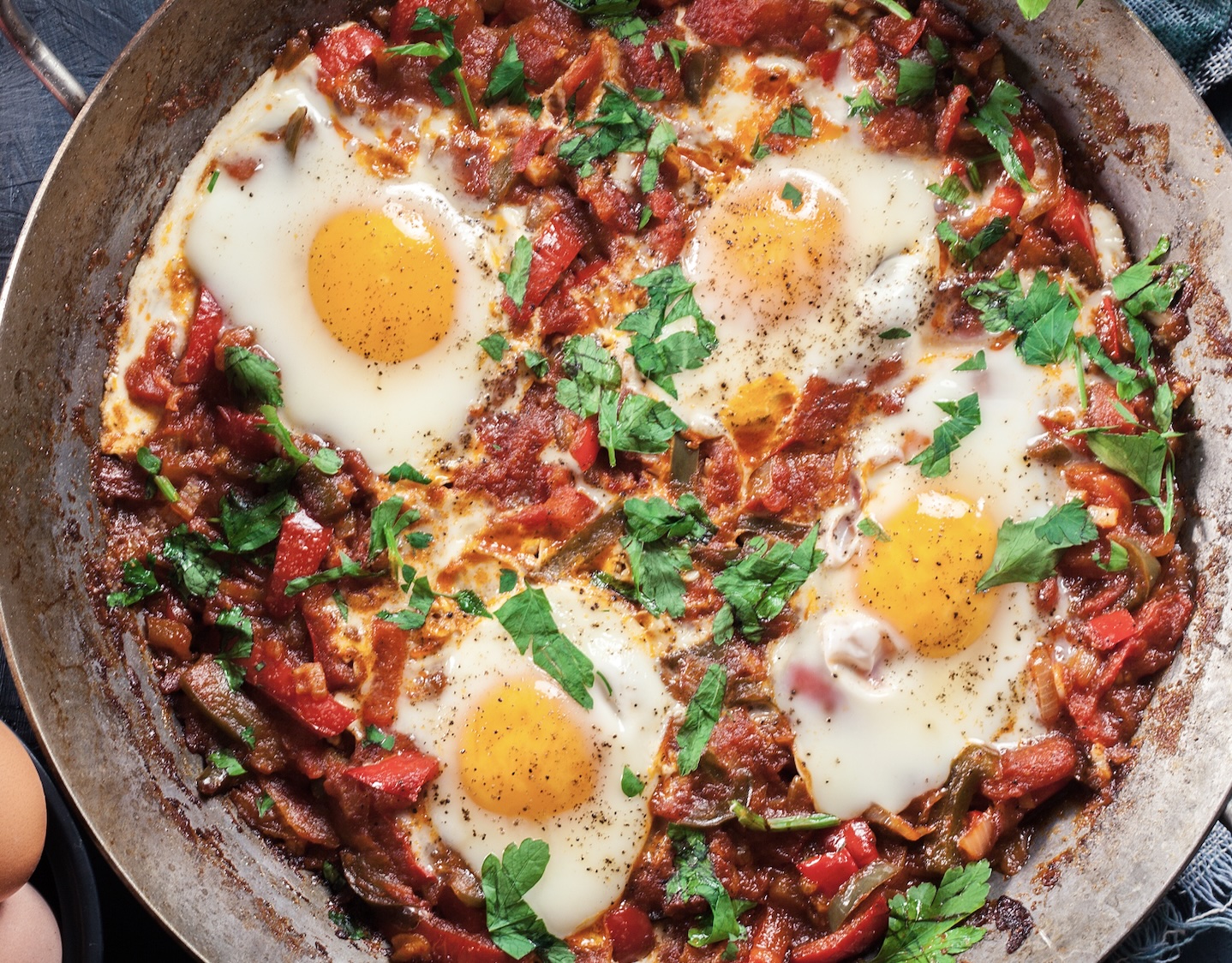 A spicy, tomato-based breakfast or dinner. Eggs poached right in a bubbling sauce of peppers, onions, tomatoes, and aromatics.
