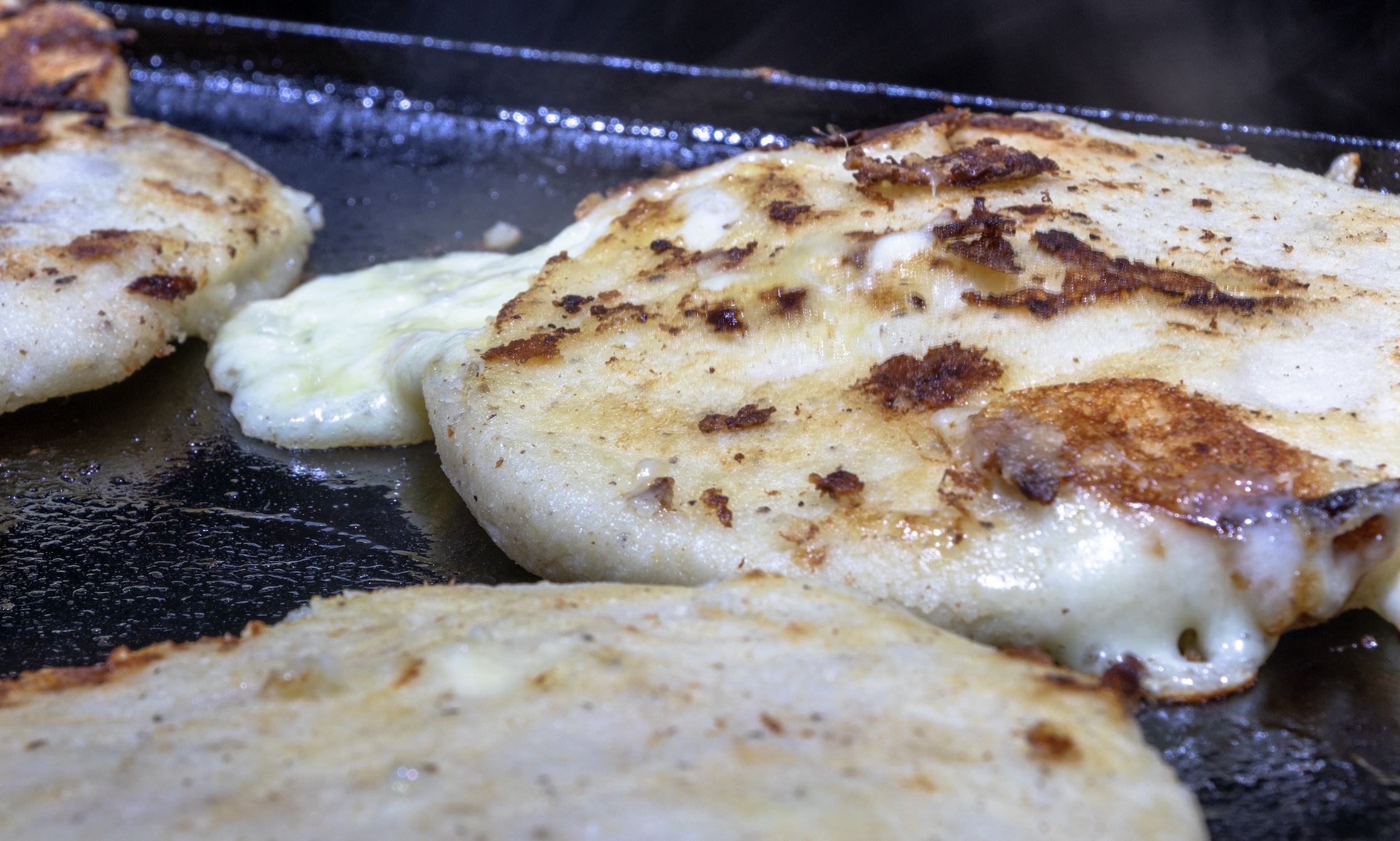 Thick, griddled corn tortillas stuffed with gooey cheese and beans. Serve it with curtido slaw, the essential topping for pupusas. A tangy, crunchy, and slightly spicy slaw that cuts through the richness of the cheese.